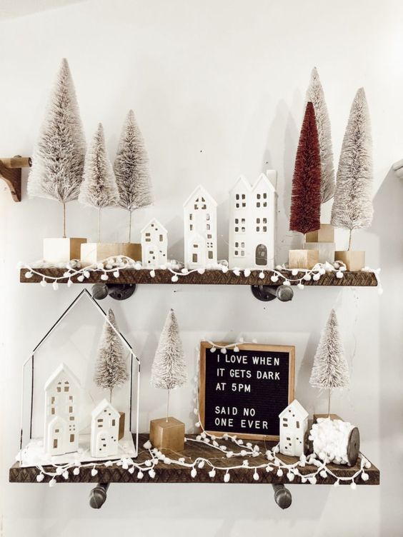 تصميم الجرف الشتوي مع منازل بيضاء صغيرة ، وكريات صغيرة ، وزجاجة بيضاء وحمراء ، وفرشاة أشجار عيد الميلاد