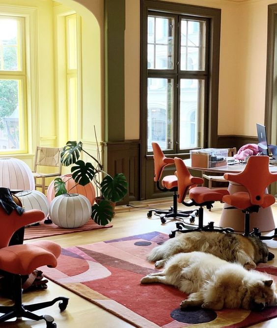 غرفة معيشة ملونة بجدران صفراء ولمسات خضراء وكراسي coquelicot وسجادة مطبوعة جريئة ومصابيح ورقية