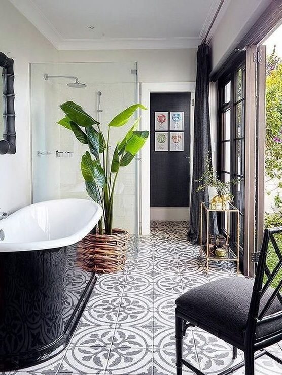 https://www.digsdigs.com/photos/2022/02/a-lovely-modern-bathroom-with-a-door-to-the-garden-a-shower-a-black-sleek-bathtub-a-black-chair-and-cool-tiles-on-the-floor.jpg