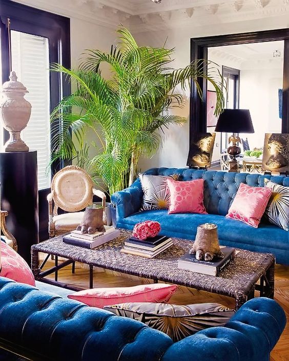 كنب مودرن باللون الازرق عصري وانيق A-maximalist-living-room-with-black-window-and-door-frames-blue-sofas-a-chic-woven-coffee-table-and-a-potted-tree-is-wow