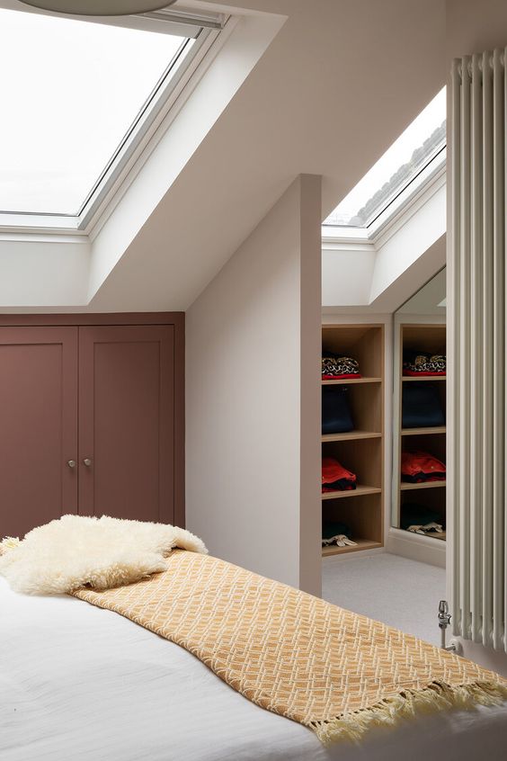 https://www.digsdigs.com/photos/2022/03/a-small-attic-closet-next-to-the-bedroom-with-built-in-storage-shelves-and-skylights-is-a-cool-and-smart-idea-for-any-home.jpg