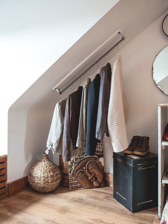 https://www.digsdigs.com/photos/2022/03/an-attic-nook-with-railing-for-the-clothes-some-decor-a-chest-and-some-mirrors-is-a-great-space-for-an-attic-home.jpg