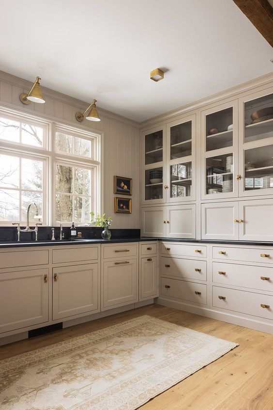 https://www.digsdigs.com/photos/2023/02/a-vintage-inspired-tan-kitchen-with-shaker-cabinets-black-soapstone-countertops-vintage-fixtures-and-sconces.jpg