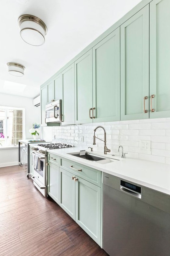 A Beautiful Mint Green Kitchen With Shaker Cabiners A White Tile Backsplahs And White Countertops Stainless Steel Appliances 