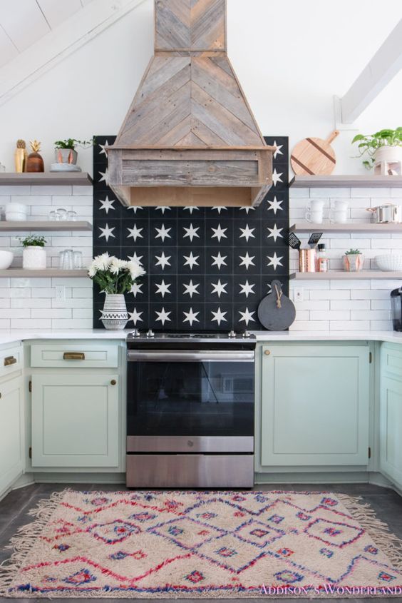 https://www.digsdigs.com/photos/2023/03/a-farmhouse-kitchen-with-mint-lower-cabinets-open-shelves-a-white-tile-backsplash-a-reclaimed-wood-hood.jpg