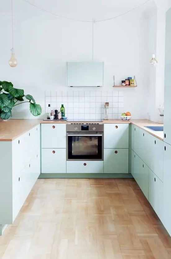 https://www.digsdigs.com/photos/2023/03/a-lovely-mint-blue-Scandinavian-kitchen-with-plywood-cabinets-butcherblock-countertops-a-square-tile-backsplash-and-pendant-bulbs.jpg