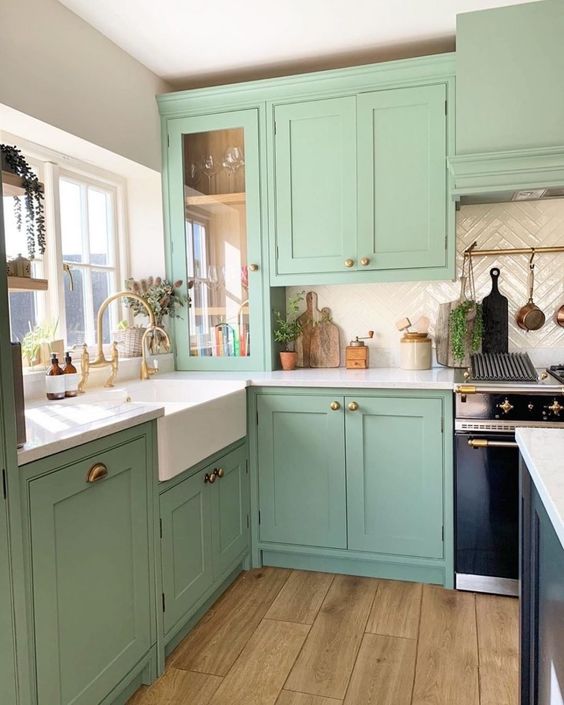 https://www.digsdigs.com/photos/2023/03/a-mitn-green-kitchen-with-shaker-cabinets-a-creamy-chevron-tile-backsplash-white-countertops-and-a-black-kitchen-island.jpg