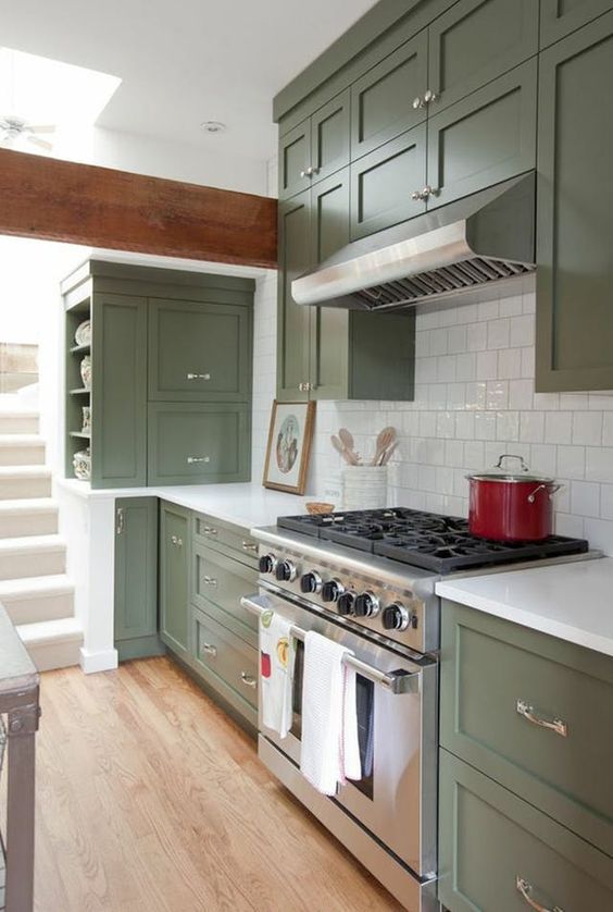 https://www.digsdigs.com/photos/2023/04/a-cool-olive-green-kitchen-with-shaker-cabinets-a-white-square-tile-backsplash-and-white-stone-countertops-shiny-knobs.jpg