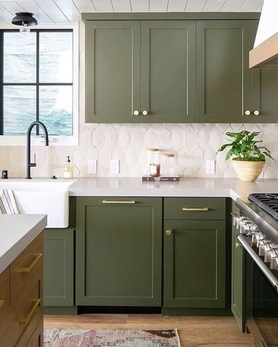 https://www.digsdigs.com/photos/2023/04/an-olive-green-farmhouse-kitchen-with-shaker-cabinets-a-catchy-white-tile-backsplash-black-fixtures-and-gold-handles-and-knobs.jpg