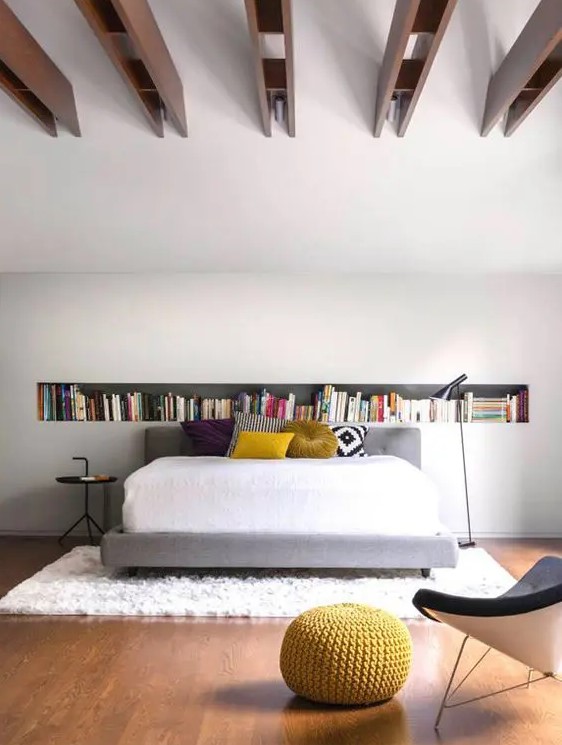 https://www.digsdigs.com/photos/2023/08/02-a-contemporary-bedroom-with-a-long-niche-shelf-a-bed-with-bold-pillows-a-black-side-table-and-black-chair.jpg