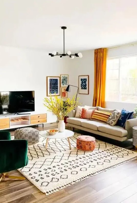 a bright mid-century modern living room with a comfy sofa, a green chair, a TV unit, printed textiles and a bright gallery wall