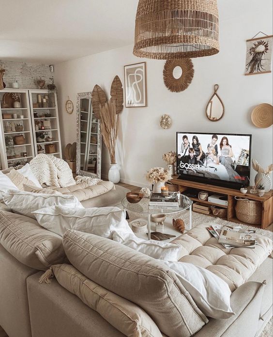 a neutral boho living room with shelves for storage and display, with fronds, woven touches, a neutral linen sofa with pillows