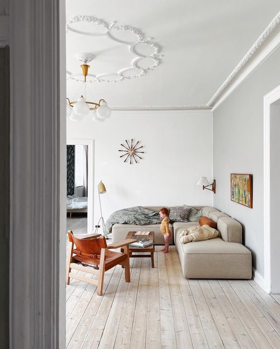 a neutral living room with a grey olefin sectional, a coffee table, an amber leather chair and some decor