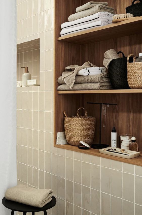 https://www.digsdigs.com/photos/2023/08/67-a-modern-bathroom-clad-with-greige-tiles-a-ntimber-niche-with-shelves-with-decor-and-some-towels-is-a-very-chic-and-cool-space.jpg