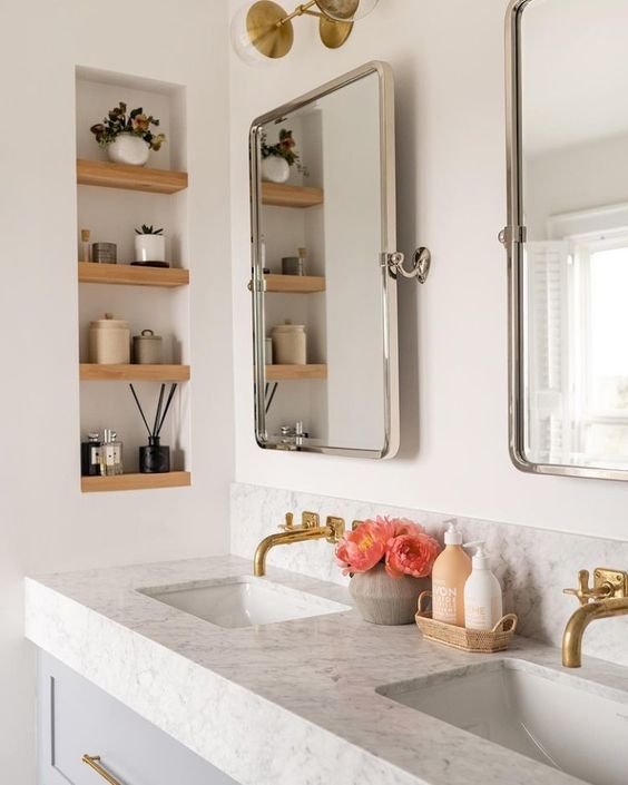 https://www.digsdigs.com/photos/2023/08/68-a-modern-bathroom-with-a-double-vanity-and-sinks-mirrors-a-niche-with-wooden-shelves-and-decor-plus-some-blooms.jpg