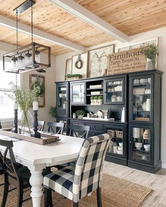 a chic modern farmhouse dining space with black storage units, a white vintage table and mismatching chairs plus a jar chandelier