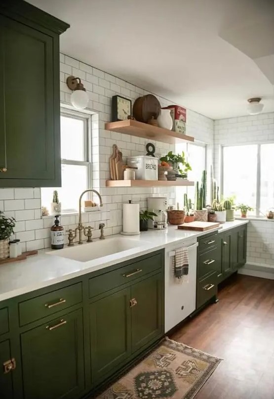 a chic modern meets boho kitchen with olive green shaker cabients, white stone countertops, white subway tiles and open shelves