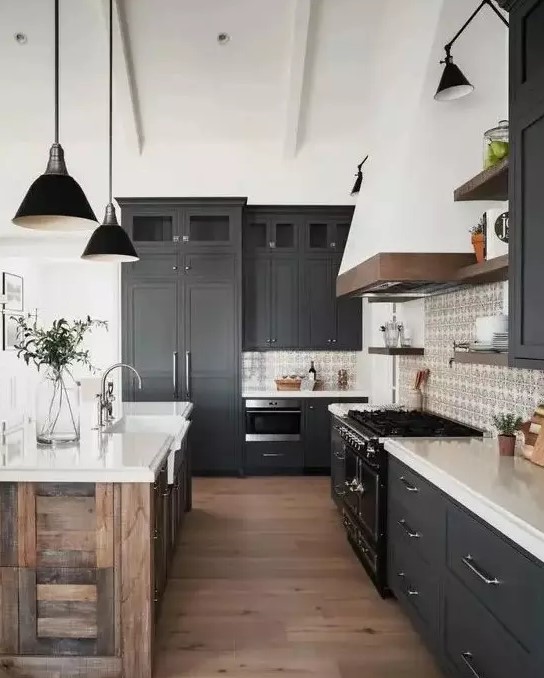 a contemporary barn kitchen with graphite grey shaker style cabinets, white stone countertops, a reclaimed wood kitchen island and black lamps