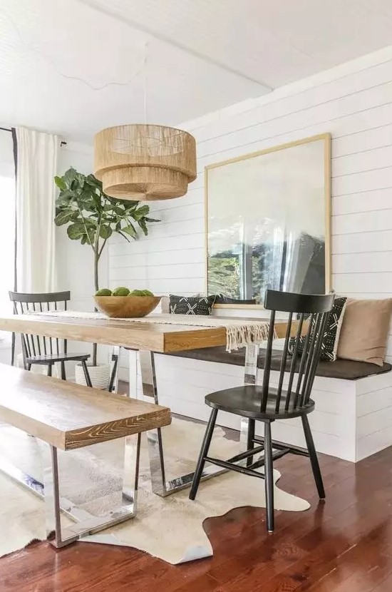 a cozy dining space with a table on a metal base and matching benches that repeat the table design