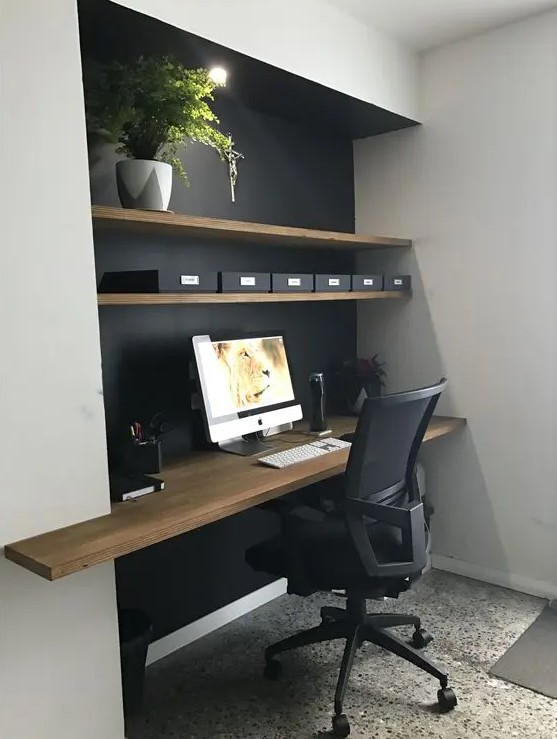 a home office in a niche, the depth of which is highlighted with a black wall and a wooden desktop