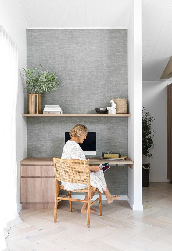 a large niche with a built-in shelf and a desk with storage drawers, greenery and decor is a cool idea for a modern space