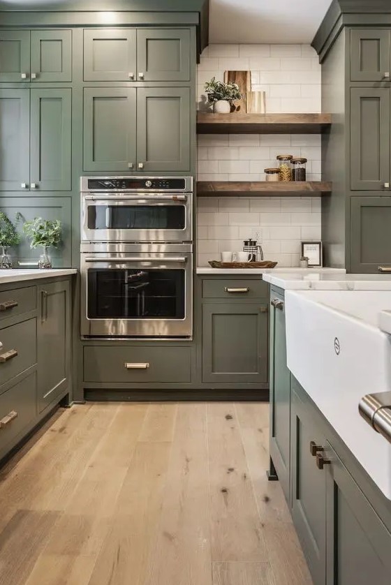 https://www.digsdigs.com/photos/2023/08/a-large-olive-green-farmhouse-kitchen-with-shaker-cabinets-white-stone-countertops-open-shelves-a-white-subway-tile-backsplash.jpg