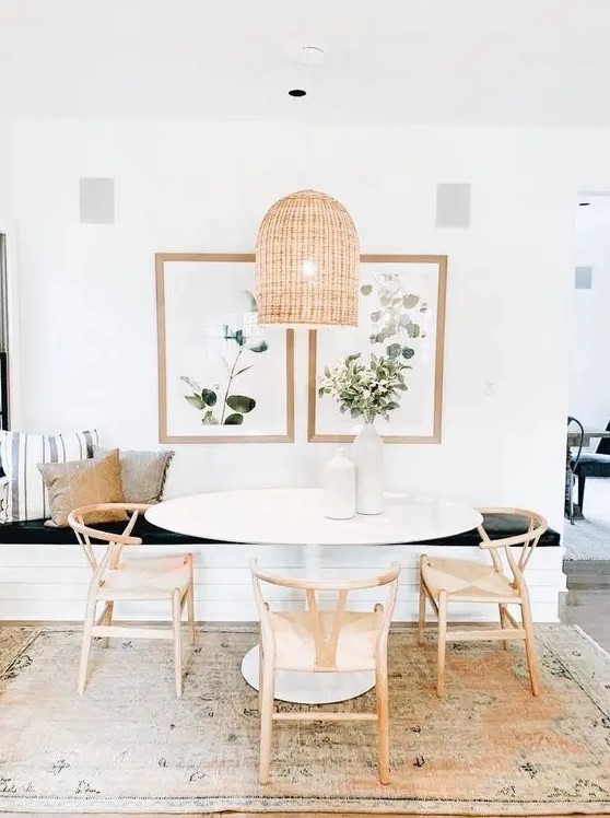 a lovely modern farmhouse dining room with a built-in bench, an oval table and wooden chairs, a woven pendant lamp