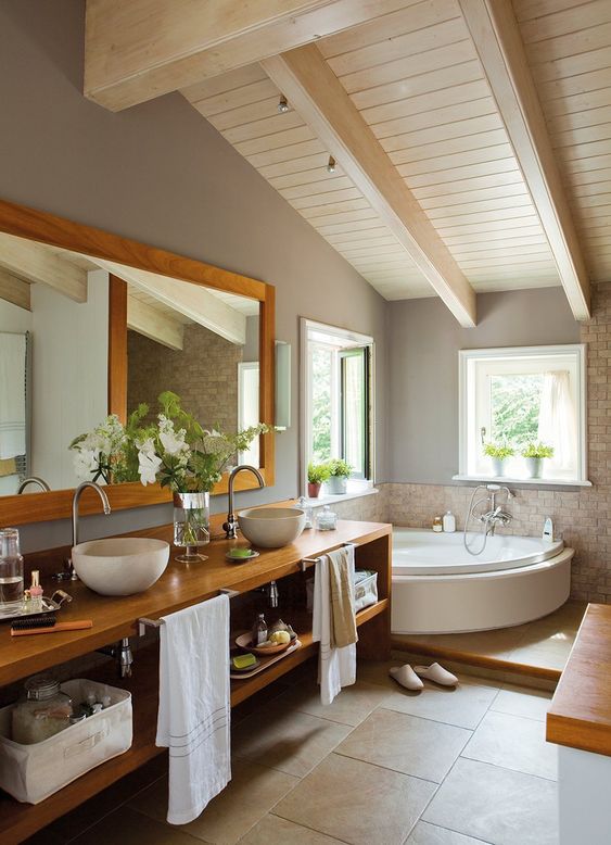 a modern farmhouse bathroom with an attic ceiling, a corner tub, a stained wall-mounted vanity, a mirror and some windows