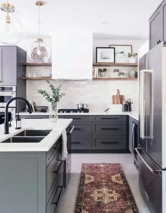 a modern farmhouse kitchen with grey cabinets, a white hood and tile backsplash and white countertops plus a boho rug