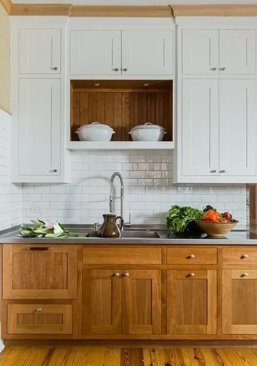 a modern farmhouse kitchen with lower stained cabinets, upper white ones, a white subway tile backsplash, a metal countertop for a cozy look and maximal functionality