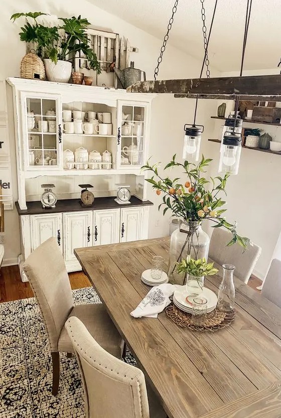 a modern neutral dining room with a neutral buffet, a stained table, upholstered chairs, a vintage ladder with bulbs