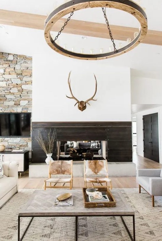 a modern rustic space with jute, fur, wood and stone in decor plus cowhide chairs