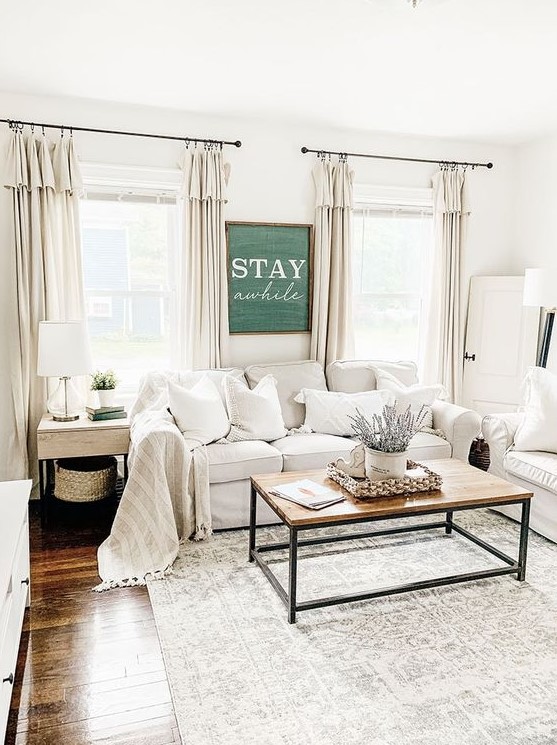 a neutral farmhouse living room with white Ektorp sofas, a wooden table, side tables and floor and table lamps