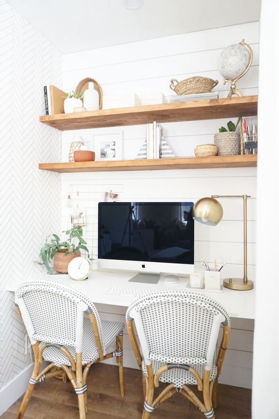 a niche with shiplap, built-in stained shelves and a desk, some rattan chairs, some decor and greenery is a cozy farmhouse space