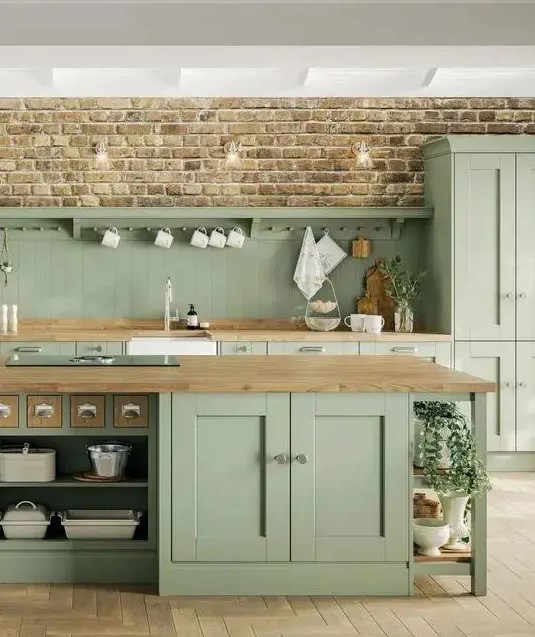 a sage green farmhouse kitchen with a beadboard backsplash and butcherblock countertops, a large kitchen island with storage compartments