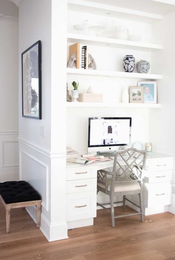 a separate nook for working with built-in shelves and a desk, a cool chair right in the kitchen matching its cabinets