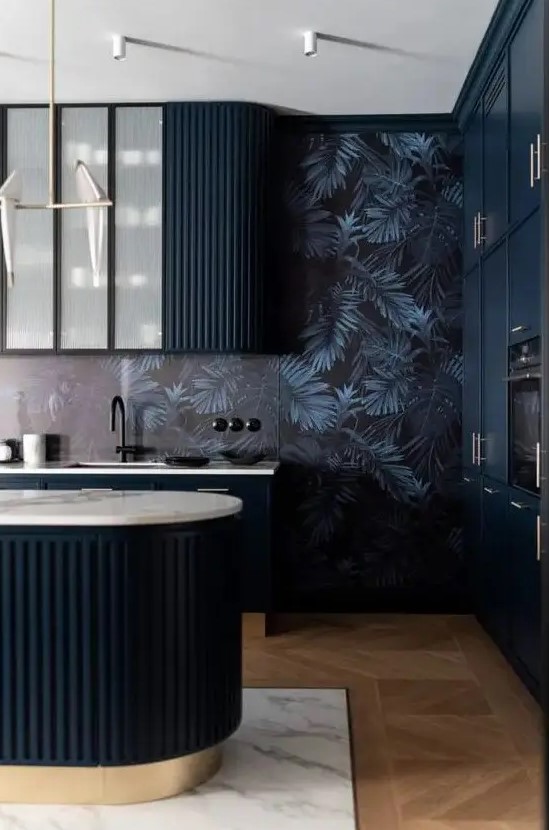 a moody and elegant kitchen with midnight blue curved cabinets and a matching kitchen island, dark wallpaper on the walls and black fixtures