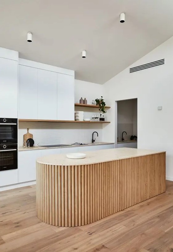 a white minimalist kitchen with a neutral stone countertop, a curved fluted kitchen island and open shelves