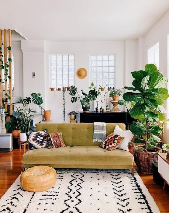 a boho meets mid-century modern living room with prints, a mustard sofa, potted plants and rattan and wicker touches