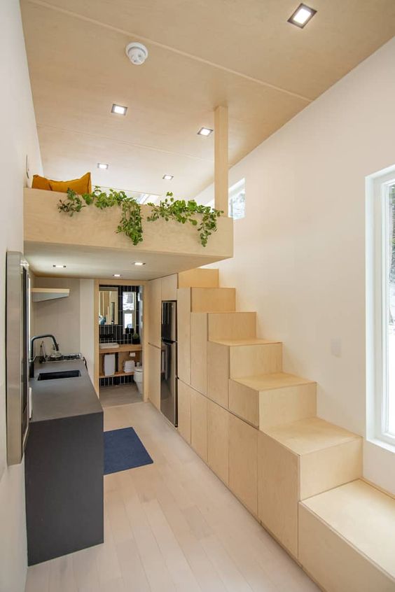 a modern kitchen of MDF composing a staircase is a perfect solution for a loft space, a concrete kitchen island is a cooking surface