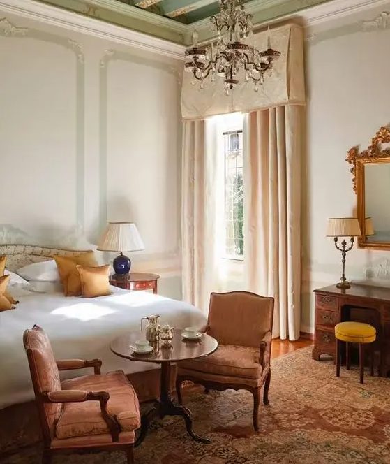 7 Furniture Trends For 2024 And 55 Ideas DigsDigs   51 An Elegant And Refined Bedroom With A Bed With Neutral Bedding A Couple Of Antique Pink Chairs A Dark Stained Desk And A Crystal Chandelier 