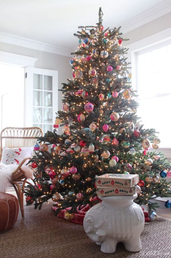 https://www.digsdigs.com/photos/2023/12/a-large-Christmas-tree-decorated-with-vintage-Christmas-ornaments-and-lights-and-a-pink-velvet-tree-skirt.jpg