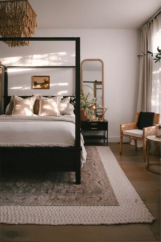 4 Bedroom Trends For 2024 And 40 Examples DigsDigs   37 A Welcoming Neutral Bedroom Done With A Black Canopy Bed A Chair A Black Nightstand Layered Rugs And A Beaded Chandelier 