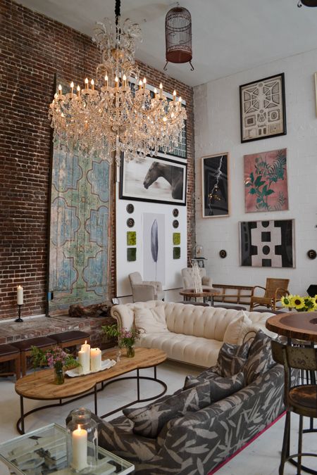 39 An Eclectic Living Room With A Brick Accent Wall A Neutral And Printed Sofa A Large Gallery Wall And A Crystal Chandelier 