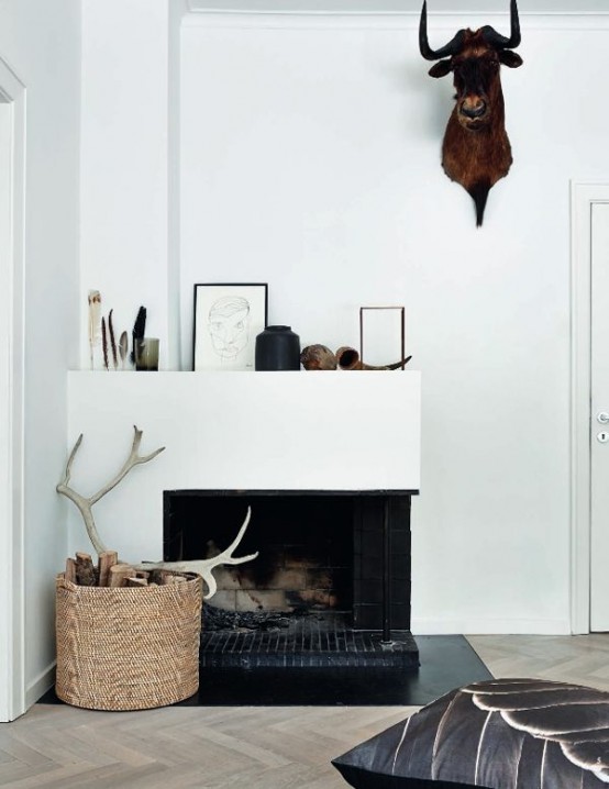 a basket with firewood and antlers plus a faux animal head on the wall for simple and modern fall decor