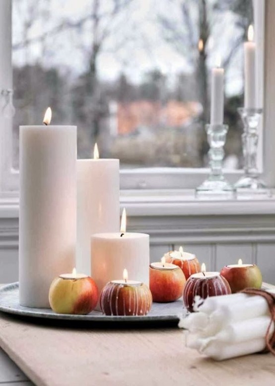 a fall Nordic centerpiece of a tray with pillar candles and apples with candles isnerted inside is a very easy decoration