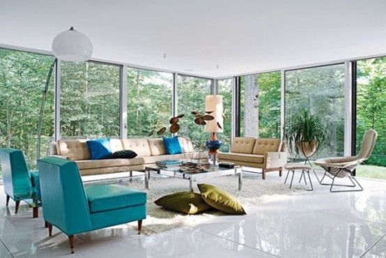 a mid-century modern living room with glazed walls, tan and turquoise seating furniture, a low coffee table and pillows and lamps