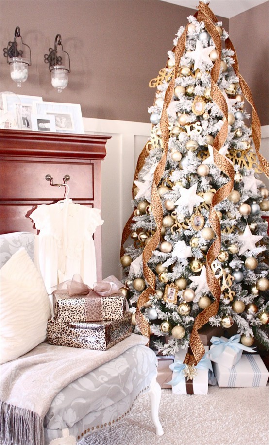 شجرة عيد الميلاد الرائعة المتدفقة مع الحلي الذهبية والفضية والنجوم البيضاء وشرائط ذهبية لامعة ونجمة ذهبية في الأعلى مدهشة