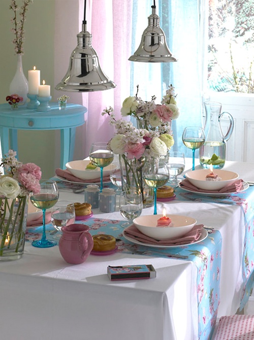 طاولات زنبركية زهرية وزرقاء زاهية مع أزهار وشموع وبورسلين ملون