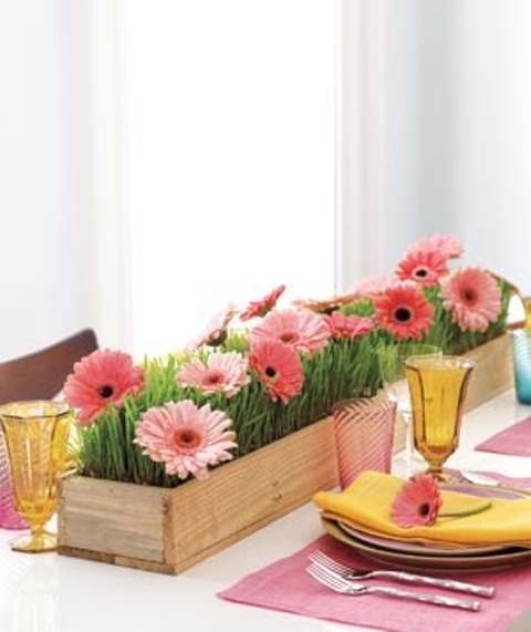 طاولة زنبركية ملونة مع قطع مركزية زهرية زاهية ومناديل وأكواب ملونة
